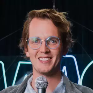 Comedian Andrew Michaan poses in front of the LMAOF logo