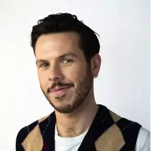 Comedian Dom McGovern smiles at the camera.