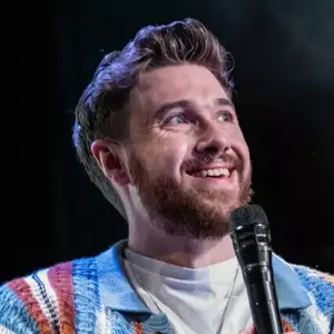 Comedian Joe Bingham performing stand-up comedy on stage at the Creative Fund: Comedy Edition.