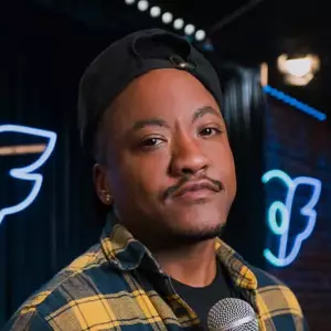 Comedian Kai Choyce poses in front of the LMAOF logo