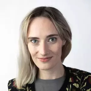 Comedian Steph Bradshaw smirks at the camera.