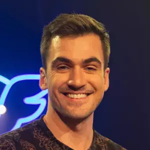 Comedian Zach Russell poses in front of the LMAOF logo
