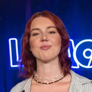 Comedian Emma Dalenberg poses in front of the LMAOF logo