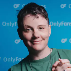 Ever Mainard poses in front of the OnlyFans backdrop.