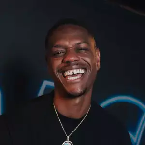 Comedian Papp Johnson poses in front of the LMAOF logo