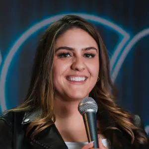 Comedian Shaena Rabbani performing stand-up comedy on stage at LMAOF