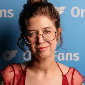 Comedian Avery Moore poses in front of the LMAOF logo.