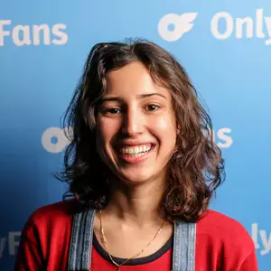 Comedian Aya Amarir poses in front of the LMAOF logo.