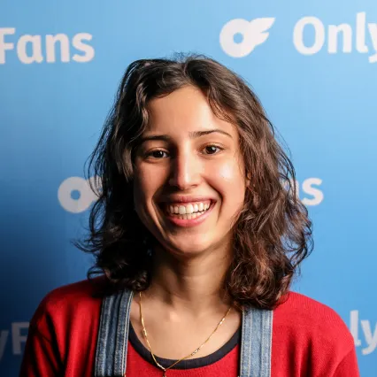 Aya_Amarir Comedian Aya Amarir poses in front of the LMAOF logo.