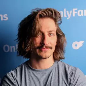 Comedian Colton Dowling poses in front of the LMAOF logo.