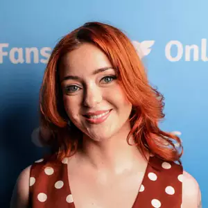 Comedian Emily Wade poses in front of the LMAOF logo.