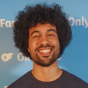 Comedian Che Durena poses in front of the OnlyFans logo at LMAOF.