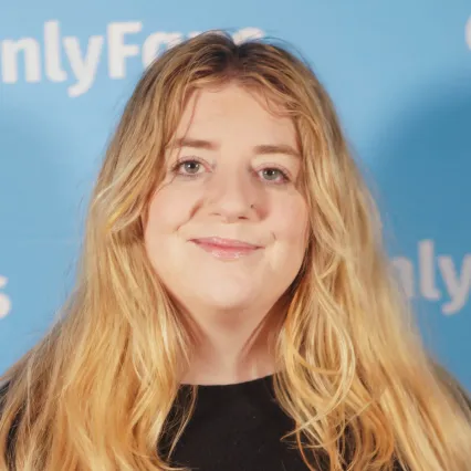 MaddieWiener Comedian Maddie Wiener poses in front of the OnlyFans logo at LMAOF.