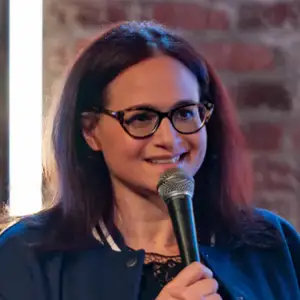 Comedian Adrienne Iapalucci on stage holding a microphone at LMAOF 108 in New York