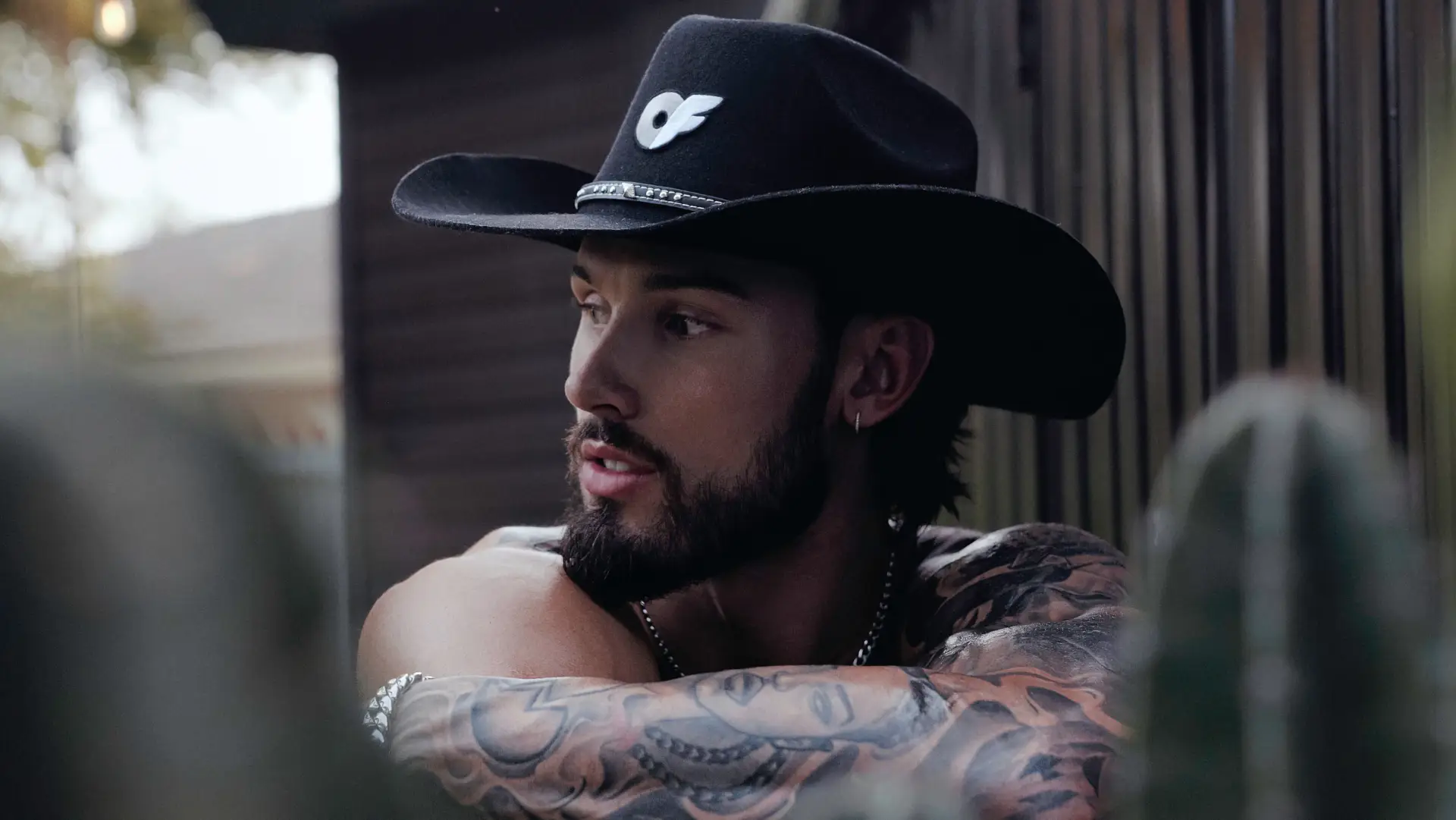 A male model looks into the distance wearing the OF Merch Western Capsule Cowboy Hat