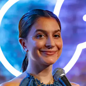 Comedian Chloe La Branche poses on stage in front of the OnlyFans logo at LMAOF 111 in New York