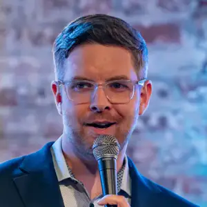 Comedian Jacob Williams poses on stage with a microphone at LMAOF 109 in New York