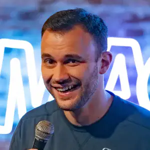 Comedian Nick Hopping poses on stage with a microphone at LMAOF 110 in New York