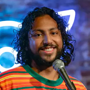 Comedian Wyatt Feegrado poses on stage in front of the OnlyFans logo at LMAOF 108 in New York