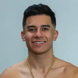 Albert Ochoa, boxer, smiles to camera with his gold chain around his neck.