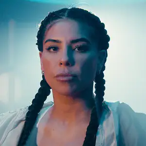 Maricela Cornejo, boxer, stares the camera down wearing two braids with smoke behind her.