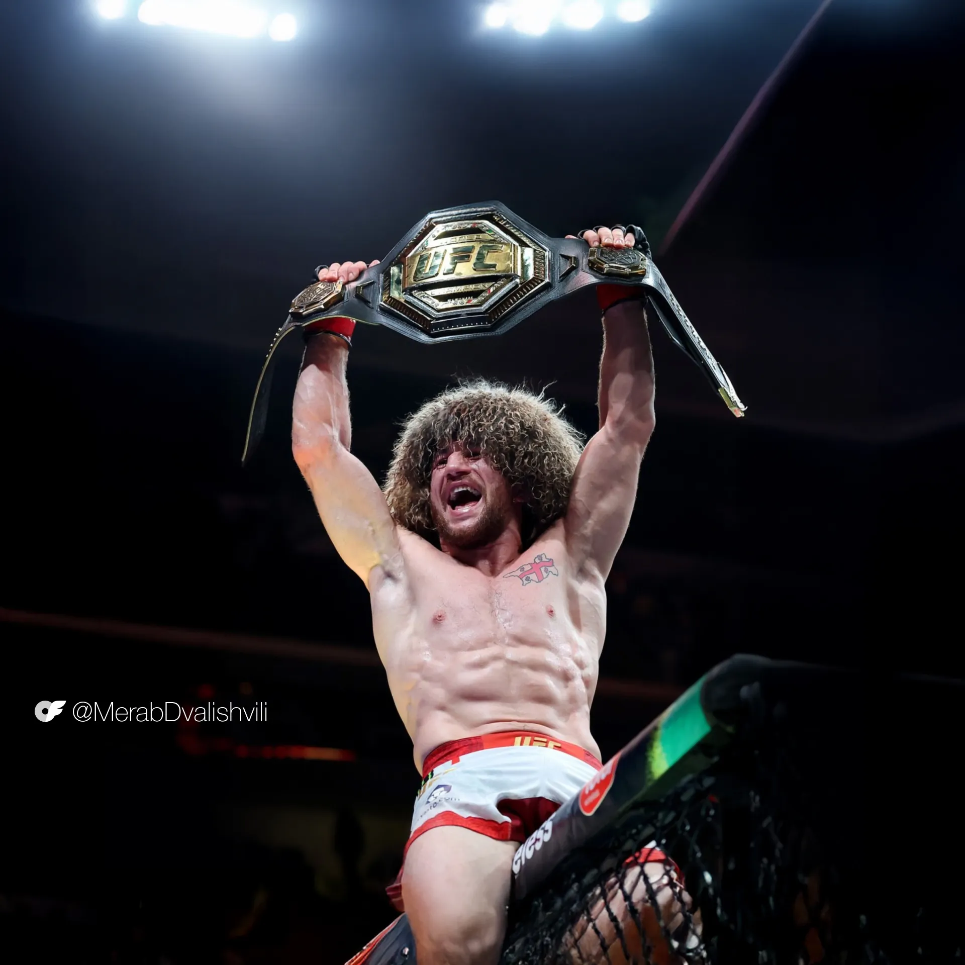 UFC fighter Merab Dvalishvili holds the bantamweight belt above his head after his victory at UFC 320