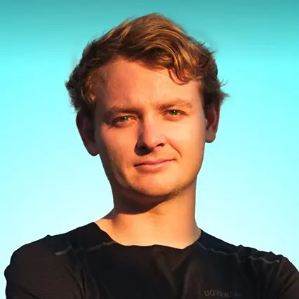 Hunter Leninger, professional endurance runner, smirks to camera dressed in all black.