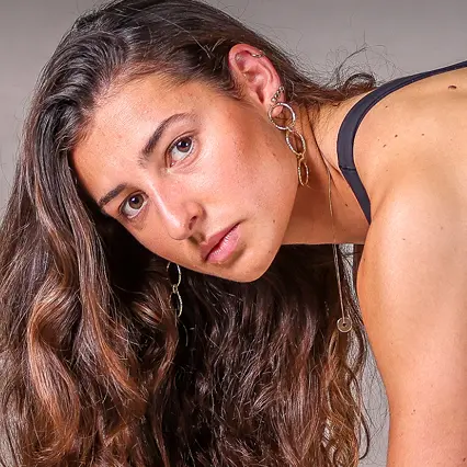 Sarah Gallego, track and field athlete, stares at the camera from a starting position.