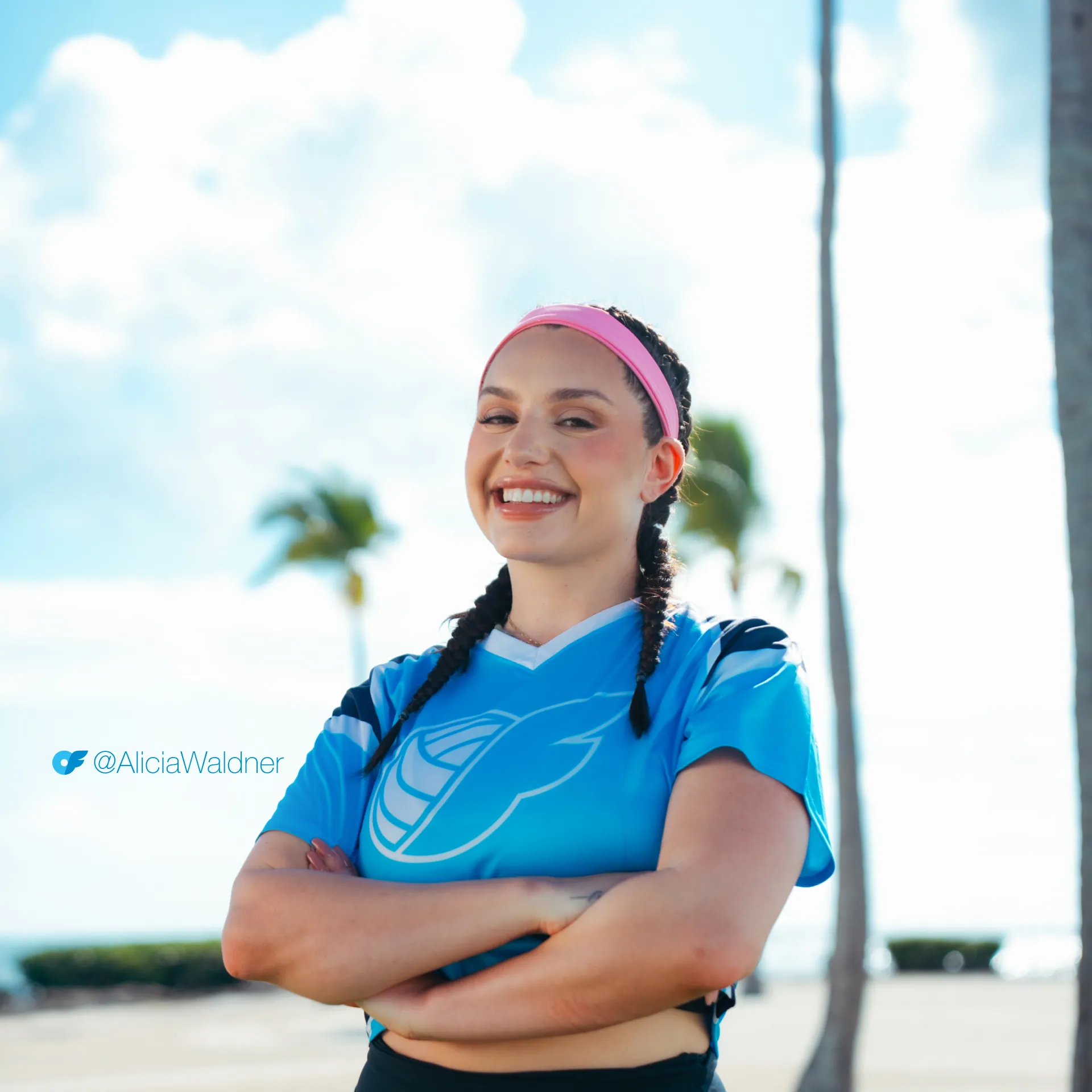 Alicia_AllScreenSizes_1920x1920 Alicia Waldner of Perfect Set and The Serve: All Access smiles, arms crossed, in a pink headband and blue jersey