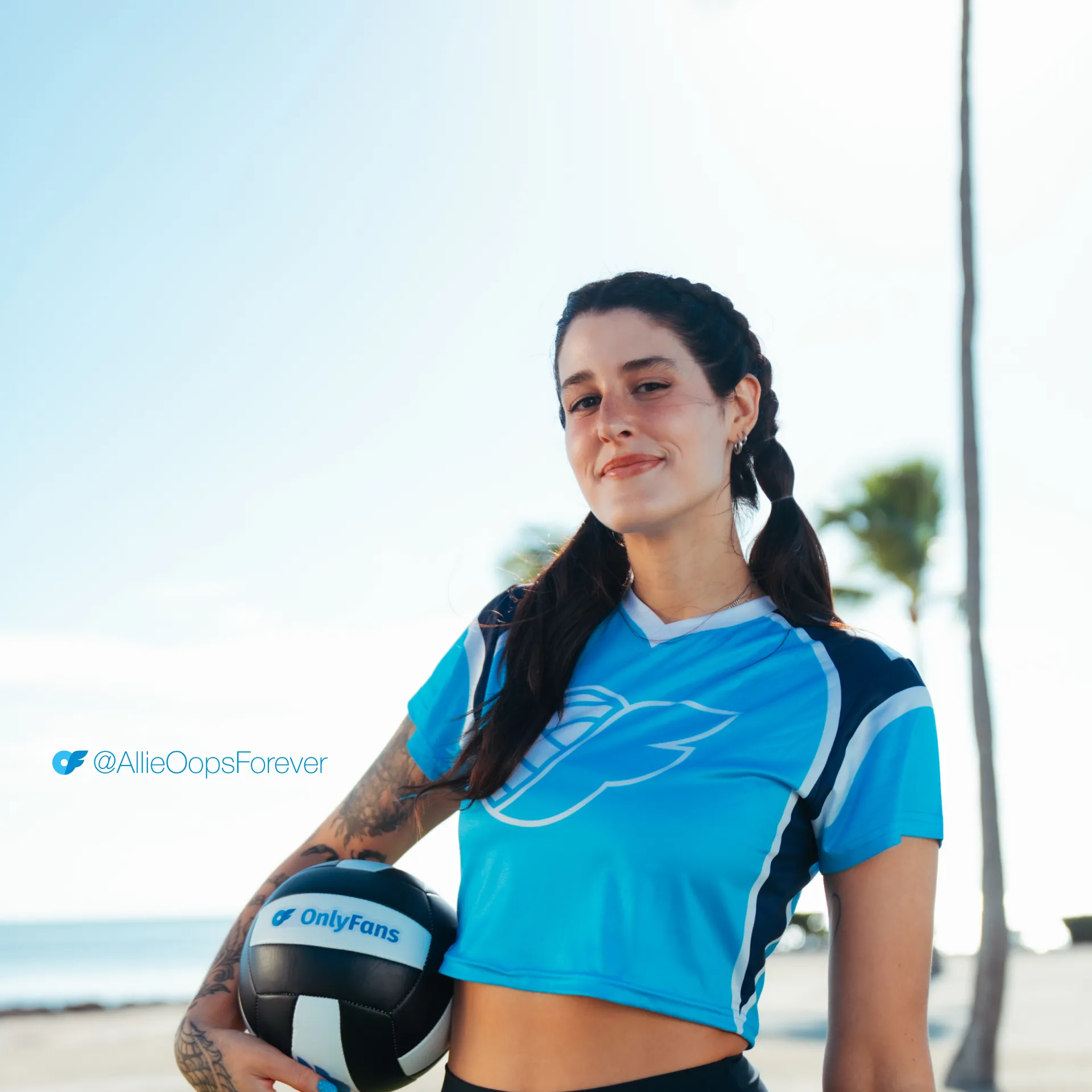 Allie_AllScreenSizes_1920x1920 Allie Oops from Perfect Set smiles in braided pigtails, holding an OnlyFans volleyball on a sunny beach